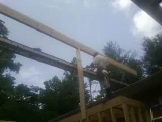 Carpenter setting a ridge beam over a new addition frame — Ice Dam Removal by Roofing Brothers in La Grande