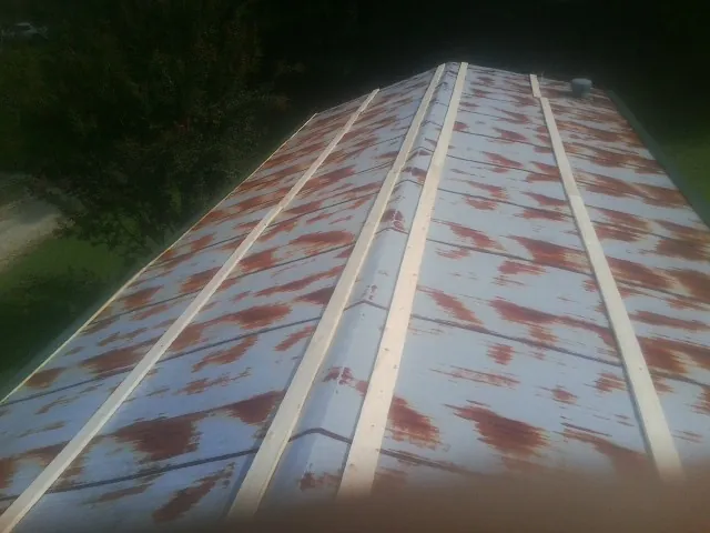 Rusted metal roof panels with new wood purlins before replacement — Storm Damage Roof Repair in La Grande by Roofing Brothers