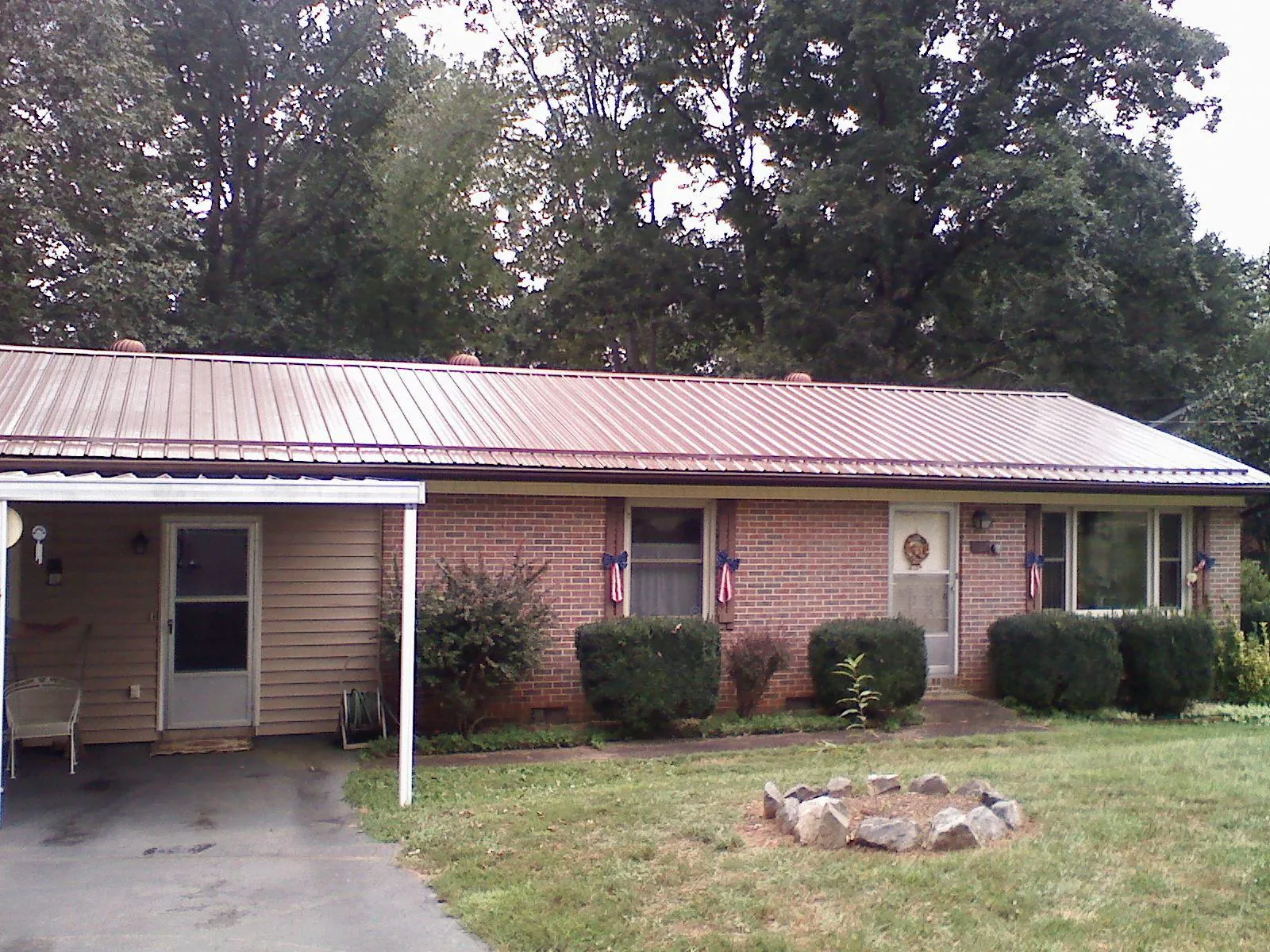 Bronze metal roof and carport on a brick ranch home — Roof Repair work by our crew in La Grande