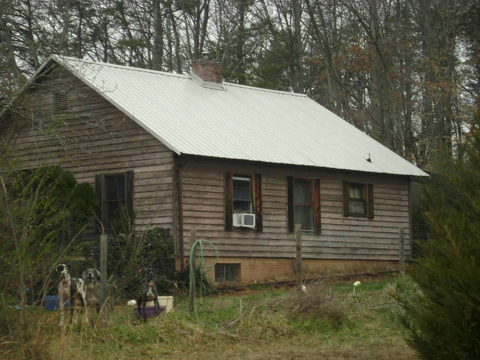 White metal roof on an old wood sided farmhouse, from a Metal Roof Installation job in La Grande